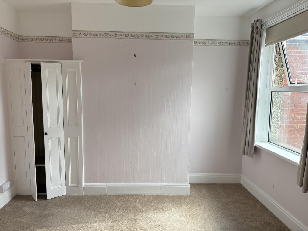 Lot: 106 - THREE-BEDROOM HOUSE IN NEED OF IMPROVEMENT - Bedroom two with fitted carpet and wallpaper
